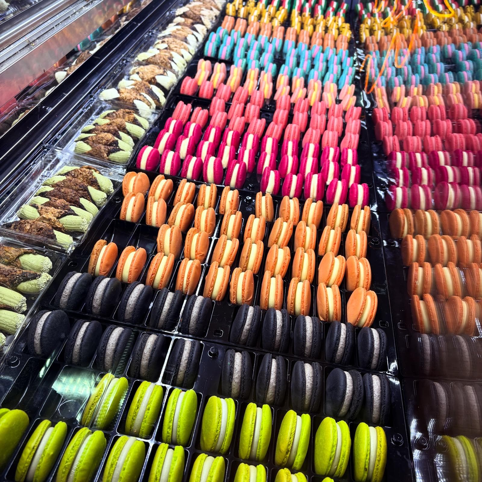 Bunte Macarons in Reihen in der Vitrine